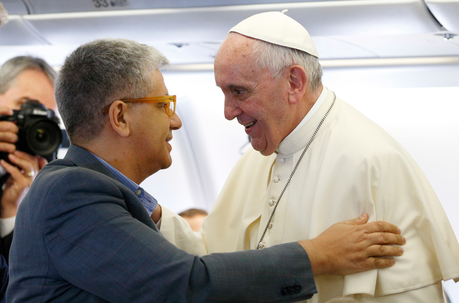 Pope Francis greets Italian journalist Andrea Tornielli aboard his flight from Rome to Quito, Ecuador, in this July 5, 2015, file photo.
